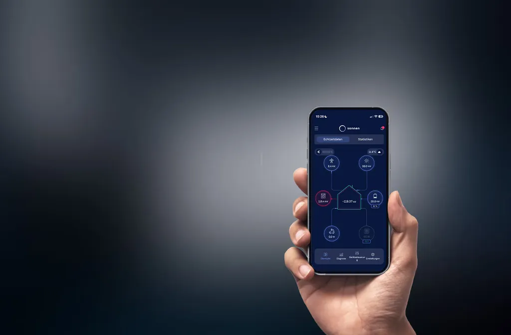 Hand holding a smartphone with the sonnen sonnenPro app showing the energy flows of a building